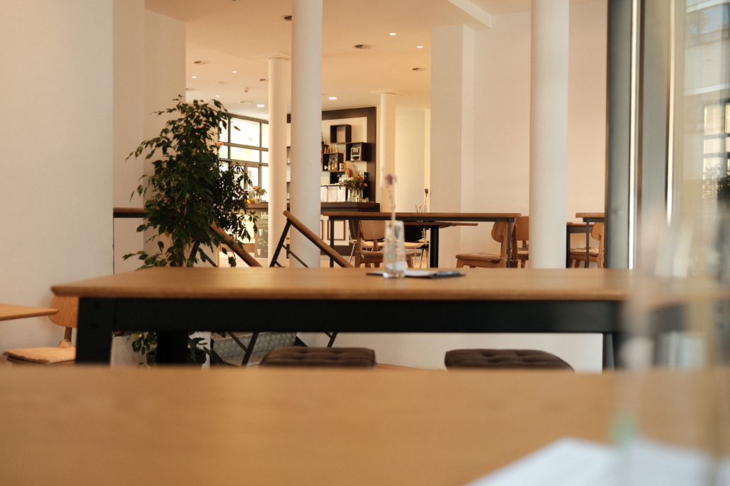 Café Podewil Sitzgelegenheiten im Café Podewil, im Hintergrund eine Pflanze und die Bar