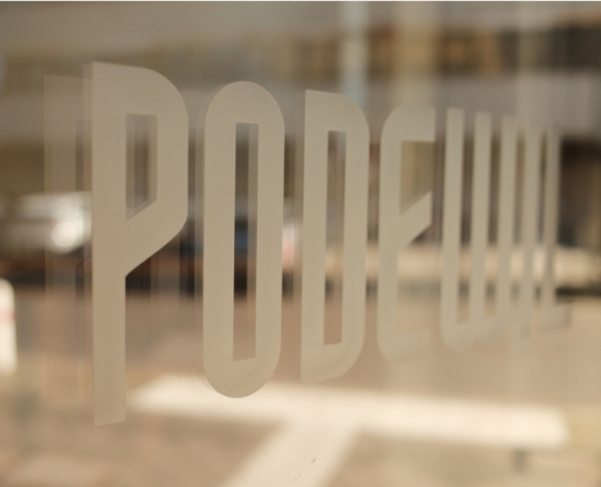 Café Podewil Logo Logo des Café Podweil auf einer Glastür mit Spiegelung