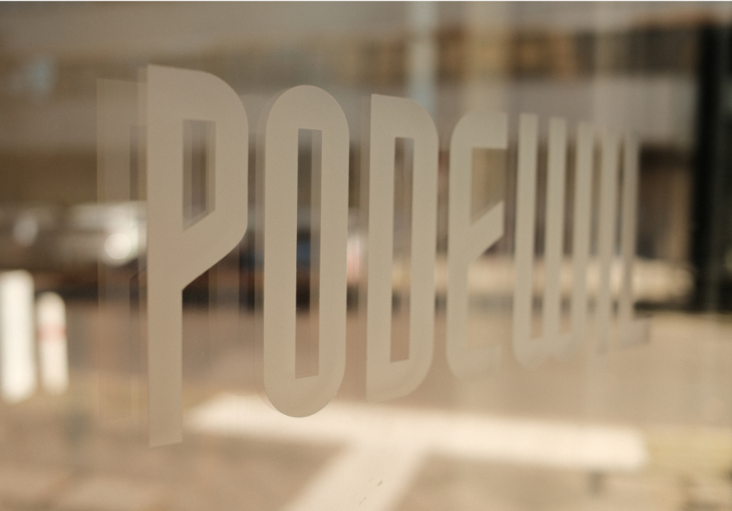 Café Podewil Logo Logo des Café Podweil auf einer Glastür mit Spiegelung