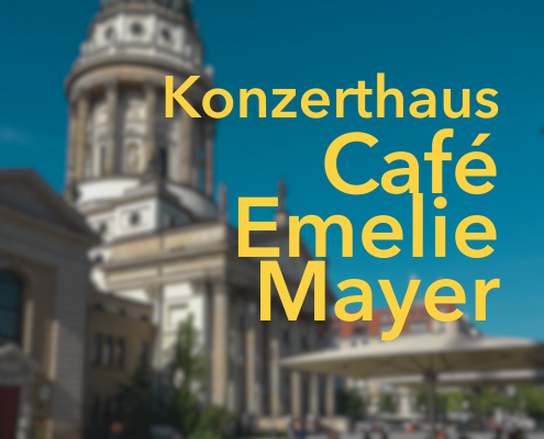 Konzerthaus Café Emelie Mayer Schrift in gelb mit französischem Dom im Hintergrund